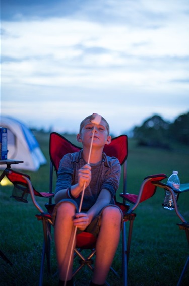 Boy blowing on a smoking marshmallow