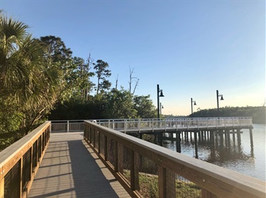 sunny boardwalk view over river