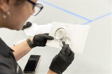 Examining fingerprints with magnifying glass