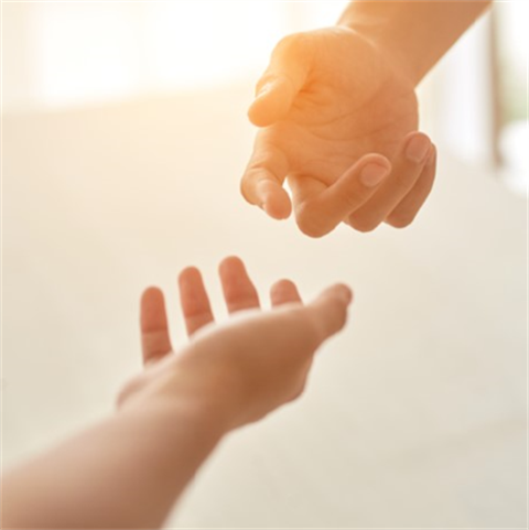 hands extended to each other in sunlight