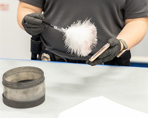 staff dusting cellphone for fingerprints